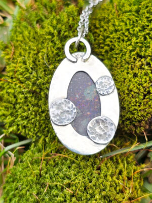 Arrière d'un collier en argent serti d'une Opale noire du Honduras avec des motifs de planètes