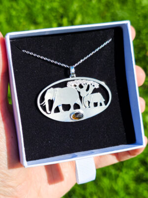 Pendentif en argent représentant des éléphants marchant devant un baobab avec une tourmaline dichroïque sertie