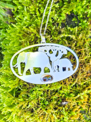 Pendentif en argent représentant des éléphants marchant devant un baobab avec une tourmaline dichroïque sertie