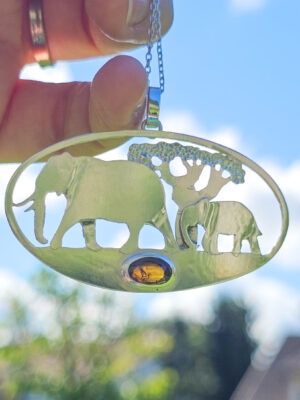 Pendentif en argent représentant des éléphants marchant devant un baobab avec une tourmaline dichroïque sertie