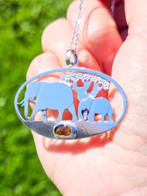 Pendentif en argent représentant des éléphants marchant devant un baobab avec une tourmaline dichroïque sertie
