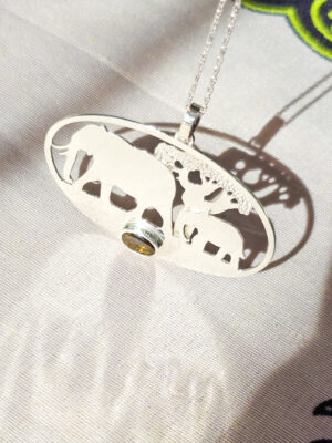 Pendentif en argent représentant des éléphants marchant devant un baobab avec une tourmaline dichroïque sertie