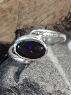 Bague en argent martelé sertie d'une Opale noire de Delanta aux feux multicolores